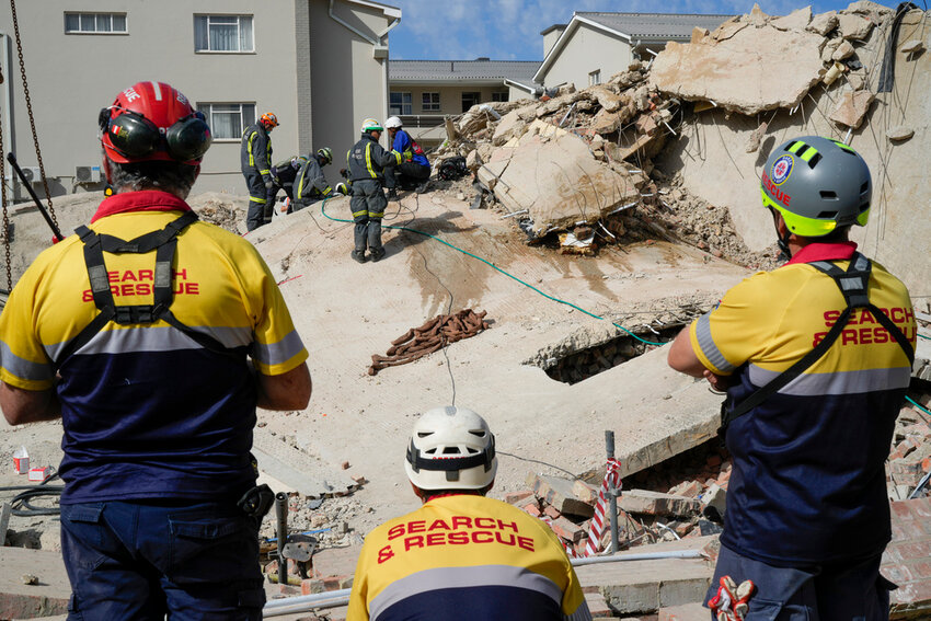 Rescue workers search the site of a building collapse in George, South Africa, Wednesday, May 8, 2024. (AP Photo/Jerome Delay)