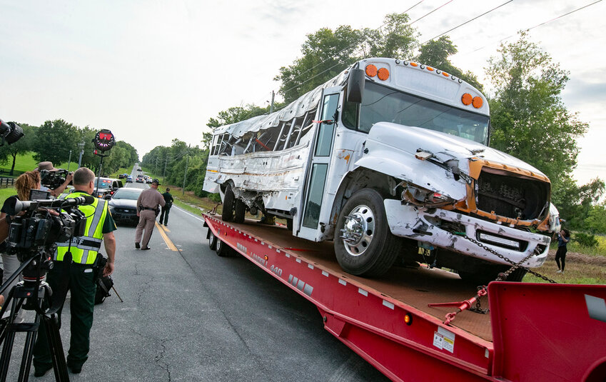 A bus is removed after it collied with a small pickup truck killing eight of the more than 50 migrant workers in the bus, Tuesday, May 14, 2024, in Ocala, Fla. (AP Photo/Alan Youngblood)