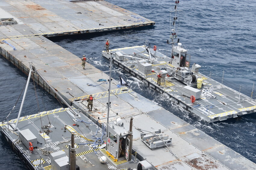 Soldiers assigned to the 7th Transportation Brigade (Expeditionary) and sailors attached to the MV Roy P. Benavidez assemble the Roll-On, Roll-Off Distribution Facility (RRDF), or floating pier, off the shore of Gaza in the Mediterranean Sea on April 26, 2024. (U.S. Army via AP)