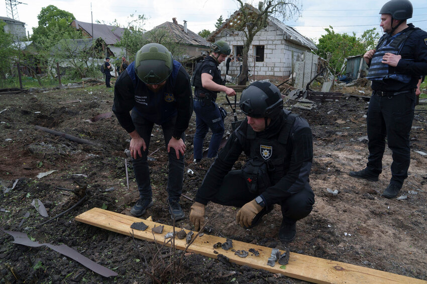 A Ukrainian police officer and war crime prosecutor inspect fragments of a glide bomb in front of damaged house, after a Russian airstrike on a residential neighbourhood in Kharkiv, Ukraine, Saturday, May 18, 2024. (AP Photo/Evgeniy Maloletka)
