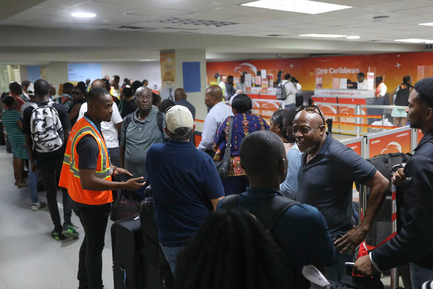Passengers stand in line at the Toussaint Louverture International Airport in Port-au-Prince, Haiti, Monday, May 20, 2024. Haiti's main international airport reopened Monday for the first time in nearly three months after gang violence forced authorities to close it in early March. (AP Photo/Odelyn Joseph)