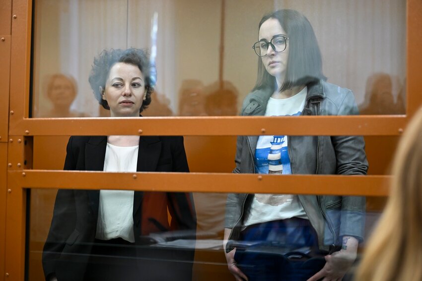 Theater director Zhenya Berkovich, left, and playwright Svetlana Petriychuk are seen in a glass cage prior to a hearing in a court in Moscow, Russia, Monday, May 20, 2024. Berkovich, a prominent independent theater director, and Petriychuk, a playwright have been behind bars since early May. Authorities claim a play they staged, 