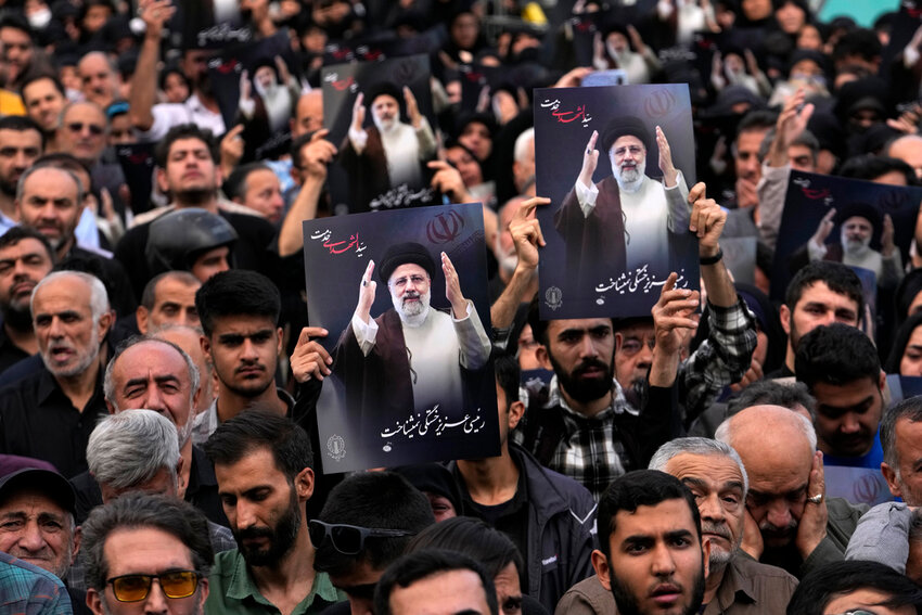 People hold up posters of President Ebrahim Raisi during a mourning ceremony for him at Vali-e-Asr square in downtown Tehran, Iran, Monday, May 20, 2024. (AP Photo/Vahid Salemi)