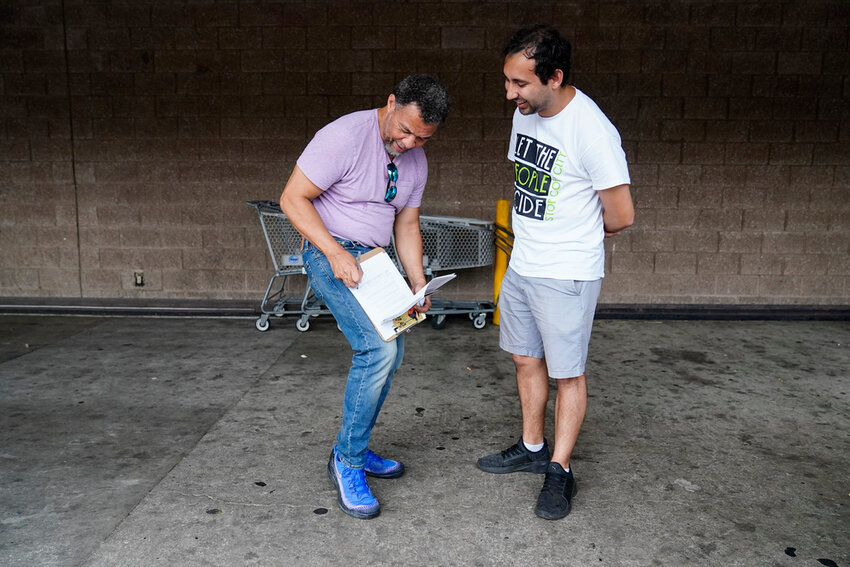 Gabriel Sanchez, right, seeks signatures trying to force a referendum to decide the fate of a proposed police and firefighter training center on Thursday, July 20, 2023, in Atlanta. (AP Photo/Brynn Anderson, File).