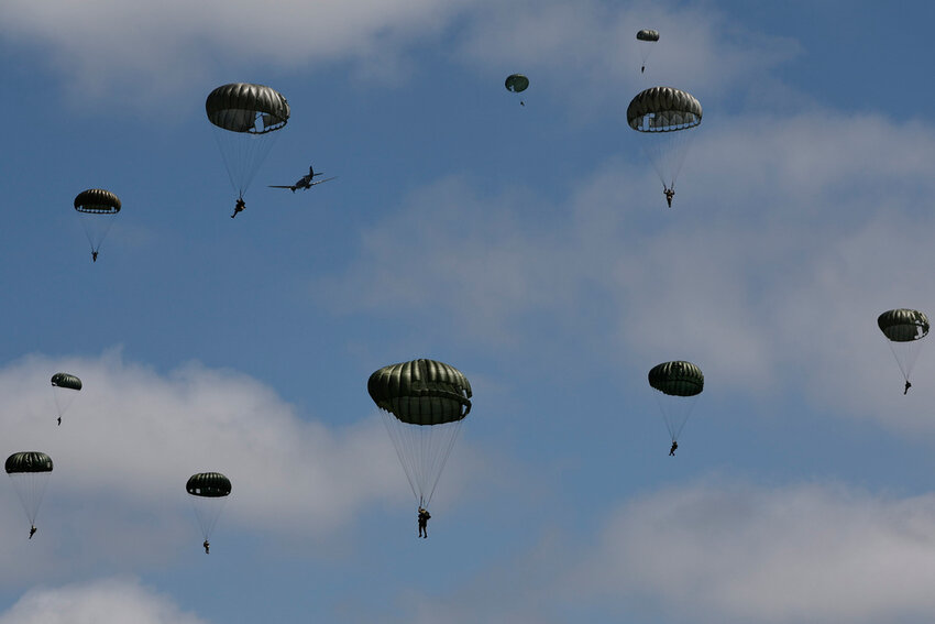 Parachutes drop in Carentan-Les-Marais in Normandy, France, Sunday, June 2, 2024, ahead of commemorations marking the 80th anniversary of D-Day. (AP Photo/Jeremias Gonzalez)