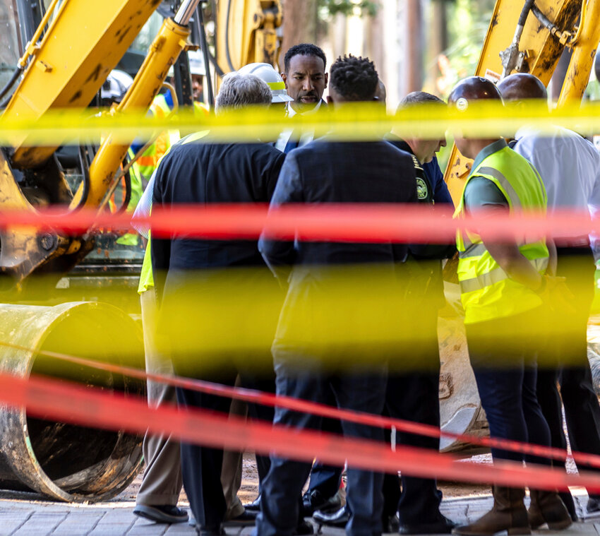 Atlanta Mayor Andre Dickens listens as crews continue to work on a broken main on West Peachtree Street in Midtown as the crisis reached its fourth day Monday, June 3, 2024. (John Spink/Atlanta Journal-Constitution via AP)
