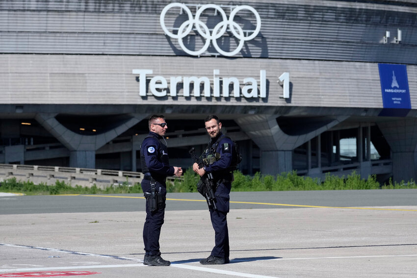 Gendarmes stand in front of the Charles de Gaulle airport, terminal 1, where the Olympic rings were installed, in Roissy-en-France, north of Paris, April 23, 2024 in Paris. (AP Photo/Thibault Camus, File)