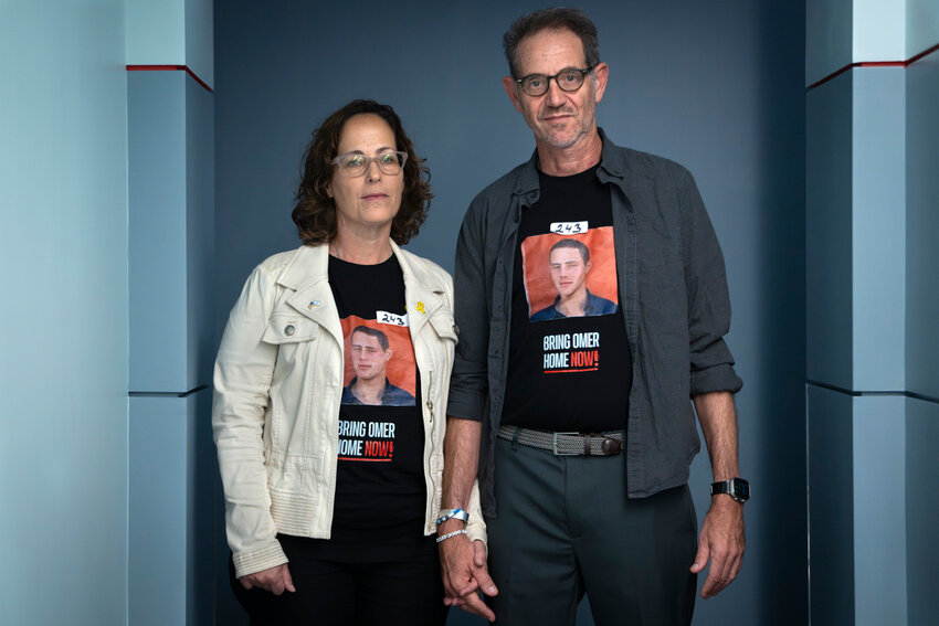 Orna Neutra, left, and her husband Ronen Neutra, of Long Island, N.Y., whose son Omer Neutra, 22, is being held hostage by Hamas in Gaza, hold hands while posing for a portrait Wednesday, June 5, 2024, in Washington. The couple wears tape with the number of days that their son has been hostage. (AP Photo/Jacquelyn Martin)