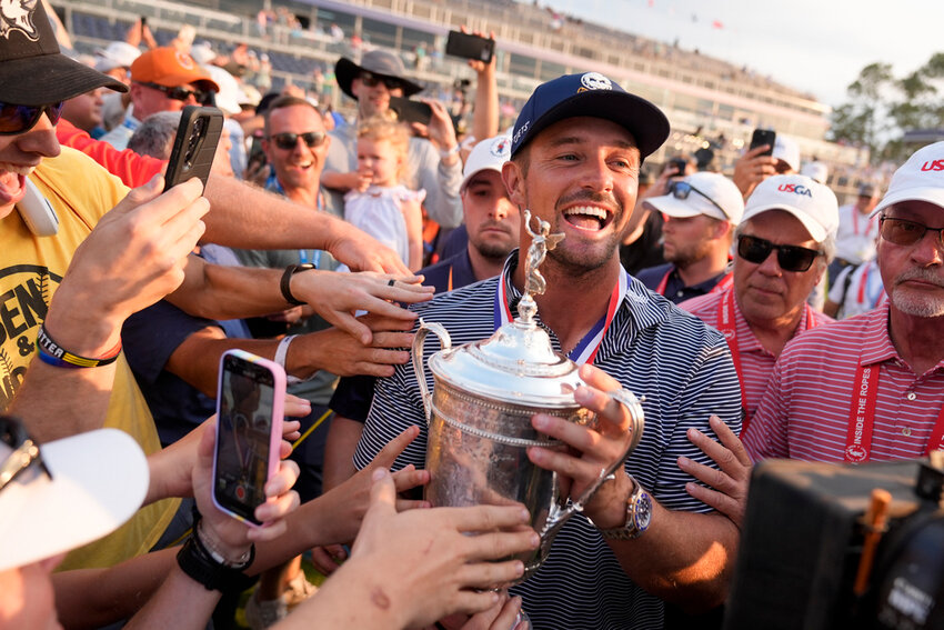 Bryson DeChambeau celebrates with fans and the trophy after winning the U.S. Open, Sunday, June 16, 2024, in Pinehurst, N.C. (AP Photo/Frank Franklin II)