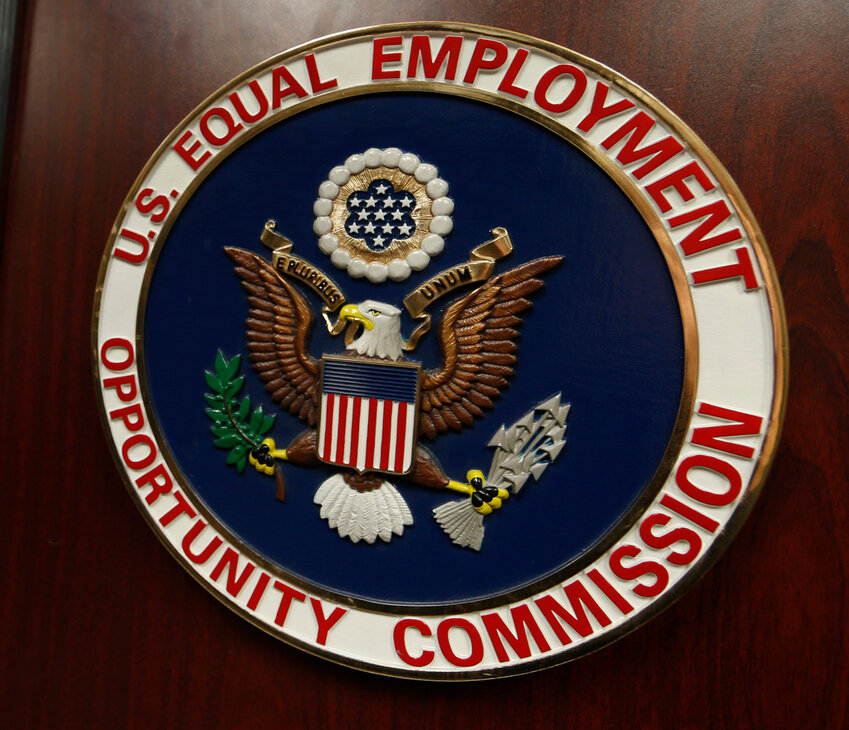 The emblem of the U.S. Equal Employment Opportunity Commission is shown on a podium. (AP Photo/David Zalubowski, File)
