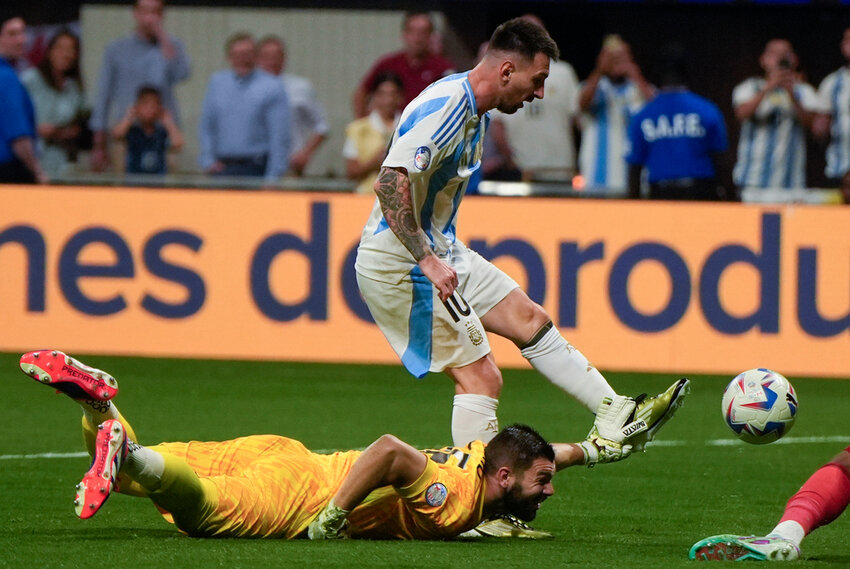 Argentina's Lionel Messi tries to score past a diving Canada goalkeeper Maxime Crepeau during the opening match of the Copa America tournament in Atlanta, Thursday, June 20, 2024. (AP Photo/Mike Stewart)