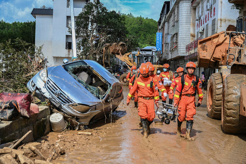 In this photo released by Xinhua News Agency, rescuers carrying rescue equipment enter a flood-affected area in Wuping County of Longyan City, southeast China's Fujian Province, Thursday, June 20, 2024. A family of six was found dead by rescuers in Fujian province, state media reported Saturday, adding to the extreme weather deaths after downpours caused landslides in the area, even as authorities extended a warning of more severe weather ahead. (Zhou Yi/Xinhua via AP)