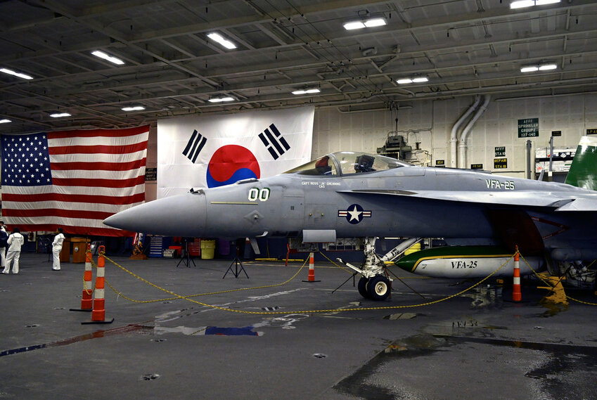 An F-18 fighter aircraft sits in the hanger of the Theodore Roosevelt (CVN 71), a nuclear-powered aircraft carrier, anchored in Busan Naval Base in Busan, South Korea Saturday, June 22, 2024. (Song Kyung-Seok/Pool Photo via AP)
