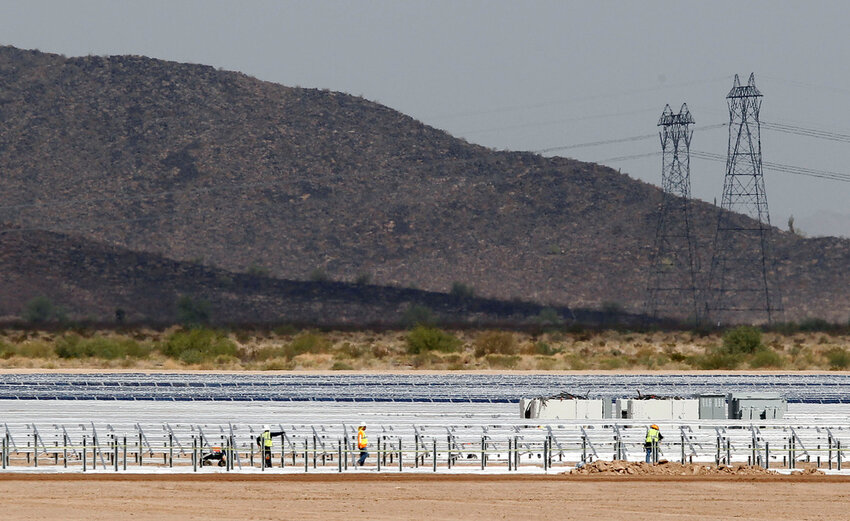 Workers continue to build rows of solar panels at a Mesquite Solar 1 facility under construction in Arlington, Ariz., Sept. 30, 2011. (AP Photo/Ross D. Franklin, File)