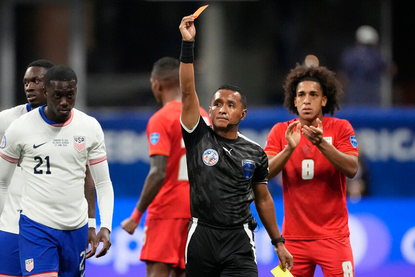 Referee Ivan Barton sends off Tim Weah of the United States, left, during a Copa America Group C match against Panama in Atlanta, Thursday, June 27, 2024. (AP Photo/Mike Stewart)
