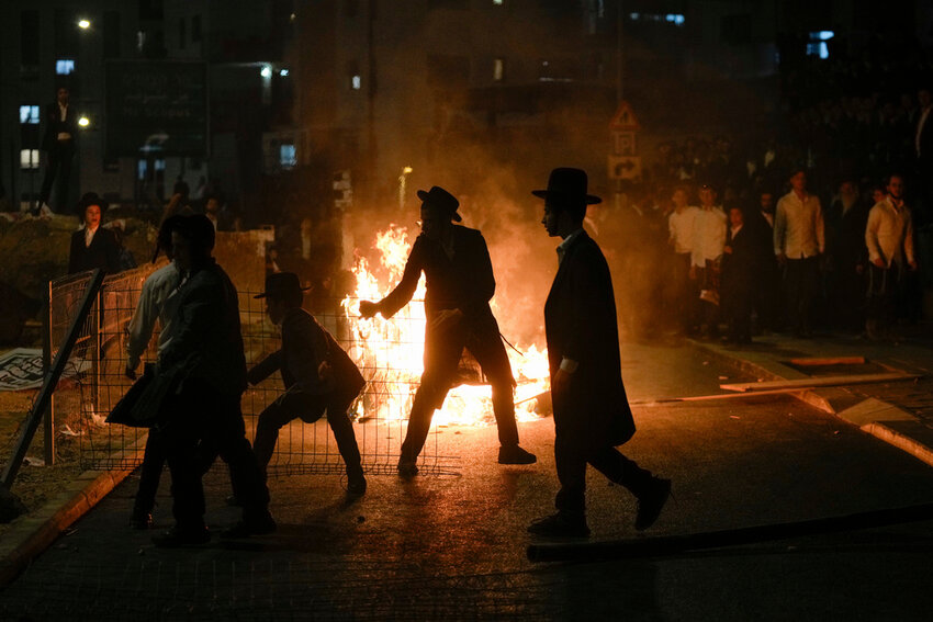 Ultra-Orthodox Jewish men burn trash during a protest against army recruitment in Jerusalem on Sunday, June 30, 2024. (AP Photo/Ohad Zwigenberg)