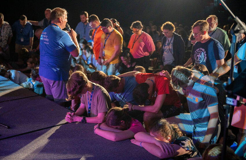 Rhon Carter, left, the Georgia Baptist Mission Board’s worship and music catalyst, and other adult volunteers pray over students responding to an altar call at SURGE Music Camp in Rome, Ga., Wednesday, June 19, 2024. (Index/Henry Durand)