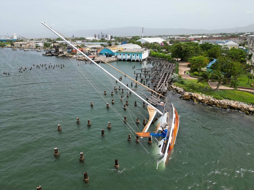 A boat damaged by Hurricane Beryl lies on its side at a dock in Kingston, Jamaica, Thursday, July 4, 2024. (AP Photo/Leo Hudson)