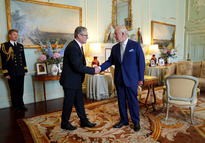 Britain's King Charles III, right, shakes hands with Keir Starmer where he invited the Labour Party leader to become prime minister and to form a new government, following the landslide general election victory for the Labour Party, in London, Friday, July 5, 2024. (Yui Mok, Pool Photo via AP)