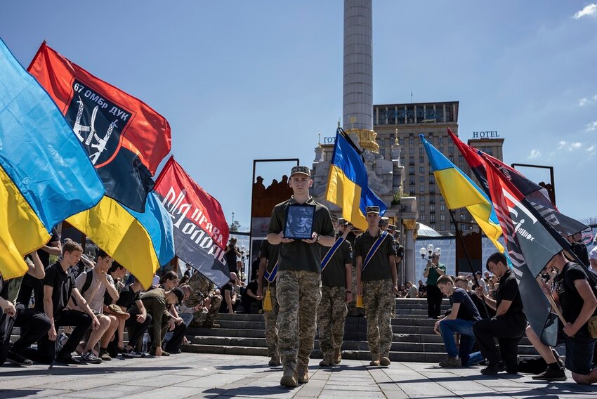 Ukrainian servicemen carry a portrait and coffin of British combat medic, volunteer, Peter Fouche, 49 who was killed on June 27 during his work in East Ukraine, at the funeral ceremony on the city's main square in Kyiv, Ukraine, Saturday, July 6, 2024. Peter was founder of a charity organization, which provides vehicles, drones and other needs to Ukrainian servicemen. (AP Photo/Alex Babenko)