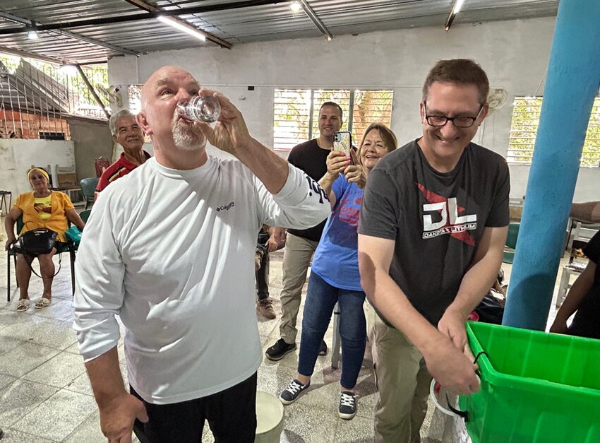 Curt Neal, left, a member of Crosspoint Church in McKinney, and Andrew Wischmeyer, director of development for Proclaim Cuba, demonstrate the effectiveness of water filters provided by Texans on Mission. (Photo/via Baptist Standard)