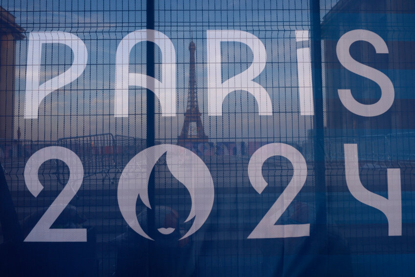 The Eiffel Tower is seen behind a Paris Olympics canvas, from the Trocadero plaza Thursday, July 18, 2024 in Paris. (AP Photo/David Goldman, File)