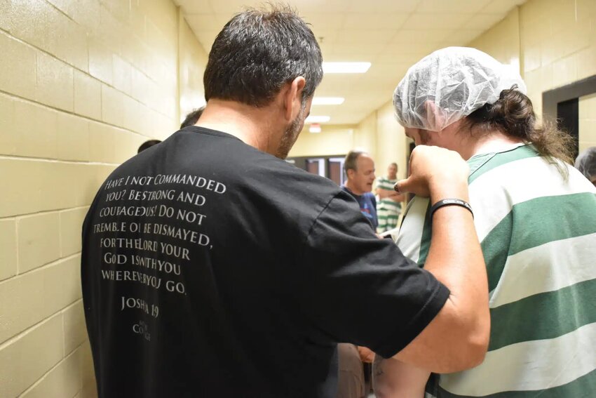 A member of an evangelism team prays with an inmate who accepted Christ during a visit to Bossier Parish Maximum Facility. (Baptist Message/Brian Blackwell)