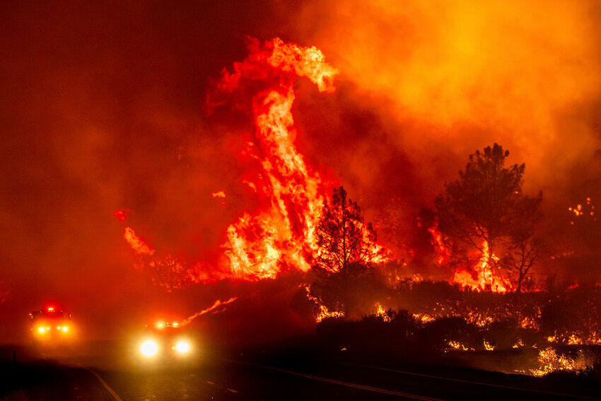 Flames leap above fire vehicles as the Park Fire jumps Highway 36 near Paynes Creek in Tehama County, Calif., Friday, July 26, 2024. (AP Photo/Noah Berger)