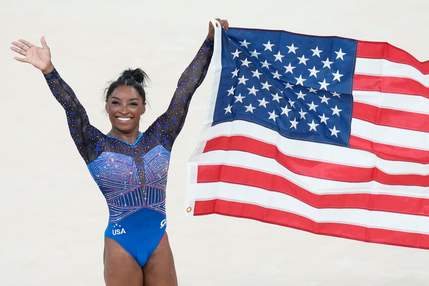 Simone Biles celebrates after winning the gold medal during the women's gymnastics all-around finals at the 2024 Summer Olympics, Thursday, Aug. 1, 2024, in Paris. (AP Photo/Francisco Seco)