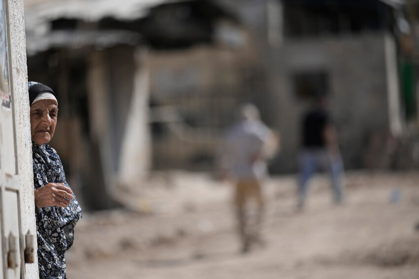A Palestinian woman watches an operation by the Israeli military in Tulkarem refugee camp in the West Bank, Saturday, Aug. 3, 2024. The Israeli military said it struck five suspected terrorists in a vehicle on their way to carry out an attack. (AP Photo/Majdi Mohammed)