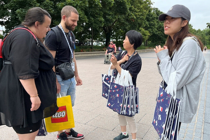 Members of the Chinese church offer the Olympic pins and other souvenirs to people they meet in Paris. (Photo/IMB)