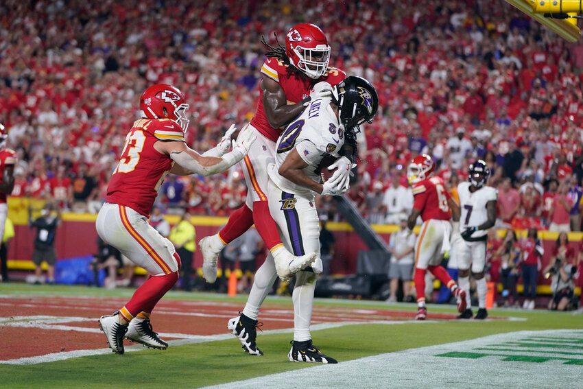 Baltimore Ravens tight end Isaiah Likely (80) catches a pass with his toe just out of bounds as Kansas City Chiefs linebackers Nick Bolton and Drue Tranquill, left, defend as time expires in the second half Thursday, Sept. 5, 2024, in Kansas City, Mo. The Chiefs won 27-20. (AP Photo/Ed Zurga)