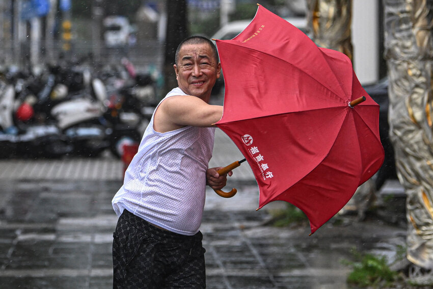 A man holding an umbrella struggles against the wind following the landfall of typhoon Yagi in Haikou, south China's Hainan Province, Friday, Sept. 6, 2024. (Pu Xiaoxu/Xinhua via AP)