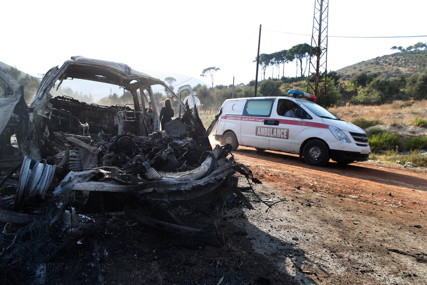 An ambulance drives past a burned vehicle in the town of Masyaf, Syria, Monday, Sept. 9, 2024. (AP Photo/Omar Sanadiki)