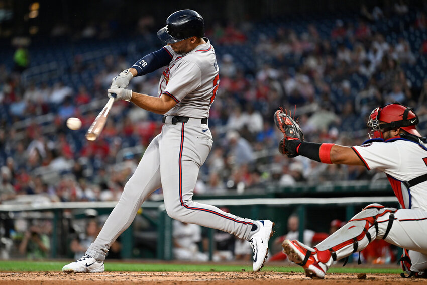 Atlanta Braves' Matt Olson, left, hits an RBI double in front of Washington Nationals catcher Keibert Ruiz during the third inning Tuesday, Sept. 10, 2024, in Washington. (AP Photo/John McDonnell)