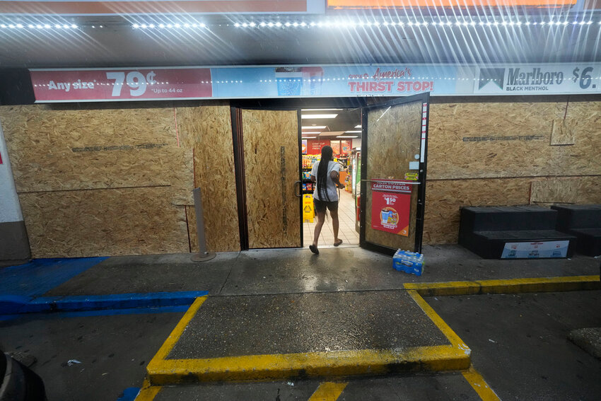 A customer enters a gas station that is boarded up in anticipation of Hurricane Francine, in Morgan City, La., Wednesday, Sept. 11, 2024. (AP Photo/Gerald Herbert)