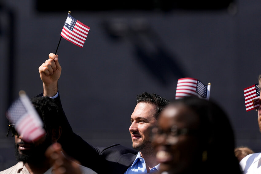 A man, part of a group of 50 new United States citizens from 25 different countries, takes part in a naturalization ceremony before a San Diego Padres game Wednesday, Aug. 21, 2024, in San Diego. (AP Photo/Gregory Bull)