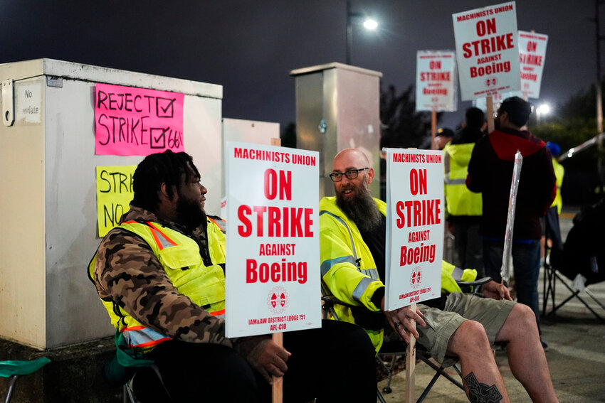 Solomon Hammond, left, and John Olson, right, both toolmakers at Boeing's Renton factory, hold picket signs after union members voted overwhelmingly to reject a contract offer and go on strike Friday, Sept. 13, 2024. (AP Photo/Lindsey Wasson)