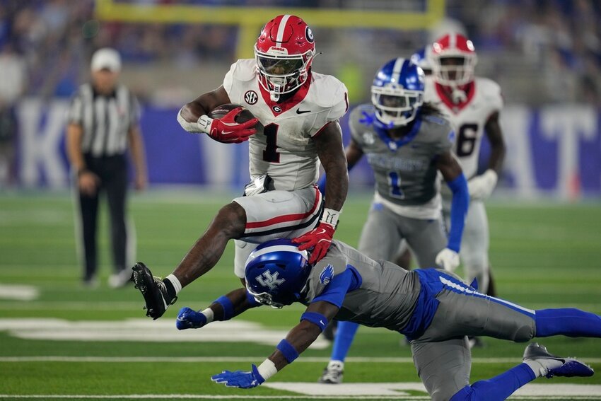 Georgia running back Trevor Etienne (1) leaps over Kentucky defensive back Kristian Story during the second half Saturday, Sept. 14, 2024, in Lexington, Ky. (AP Photo/Darron Cummings)