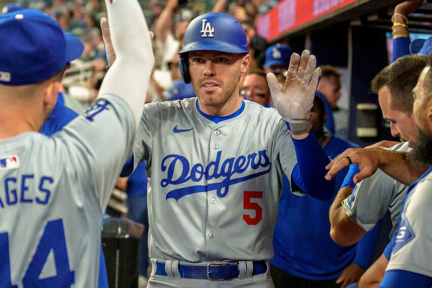 Los Angeles Dodgers' Freddie Freeman celebrates in the dugout after hitting a three-run home run in the seventh inning against the Atlanta Braves, Monday, Sept. 16, 2024, in Atlanta. (AP Photo/Jason Allen)