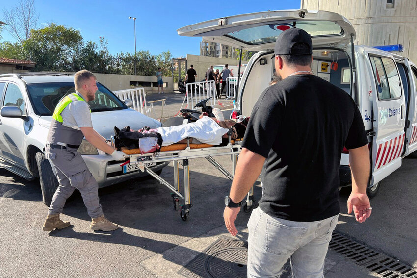 Civil Defense first responders carry a wounded man whose handheld pager exploded, at al-Zahraa hospital in Beirut, Lebanon, Tuesday, Sept. 17, 2024. (AP Photo/Hussein Malla)