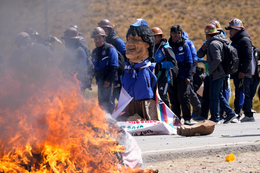 An effigy of former President Evo Morales burns on a road in Vila Vila, Bolivia, to block Morales supporters who are marching to the capital to protest the government of current President Luis Arce in an escalation of a political dispute between the two politicians, Tuesday, Sept. 17, 2024. (AP Photo/Juan Karita)