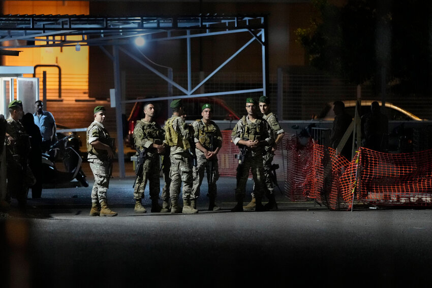 Lebanese soldiers stand guard as their comrades prepare to detonate a walkie-talkie that was found at the parking of the American University Hospital, in Beirut, Lebanon, Wednesday, Sept. 18, 2024. (AP Photo/Hassan Ammar)