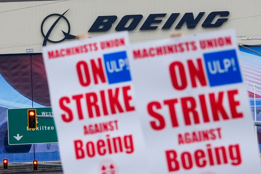 Boeing workers wave picket signs as they strike after union members voted to reject a contract offer that included a 30% pay raise over four years, Sunday, Sept. 15, 2024, near the company's factory in Everett, Wash. (AP Photo/Lindsey Wasson)