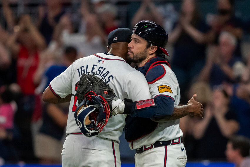 Atlanta Braves pitcher Raisel Iglesias, left, celebrates the win with catcher Travis d'Arnaud, right, over the New York Mets, Tuesday, Sept. 24, 2024, in Atlanta. (AP Photo/Jason Allen)