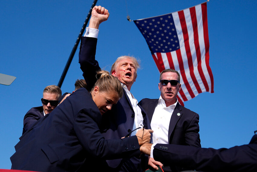 U.S. Secret Service agents surround Republican presidential candidate former President Donald Trump after he was shot at a campaign rally, July 13, 2024, in Butler, Pa. (AP Photo/Evan Vucci, File)