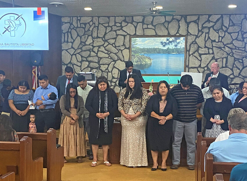 Phillip Gandy, back right, pastor of Liberty Church, Waynesboro, leads a prayer of commitment with Iglesia Bautista Libertad pastor Uzziel Reyes, fifth from left, in their new church building. (Photo/Iglesia Bautista Libertad via The Baptist Record)