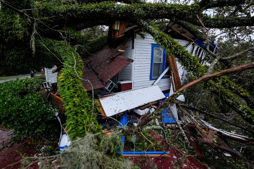 A fallen oak tree lies atop a damaged 100-year-old home after Hurricane Helene moved through the area, Friday, Sept. 27, 2024, in Valdosta, Ga. (AP Photo/Mike Stewart)