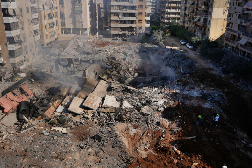 People gather near the site of an airstrike that killed Hezbollah leader Hassan Nasrallah in Beirut's southern suburbs, Sunday, Sept. 29, 2024. (AP Photo)