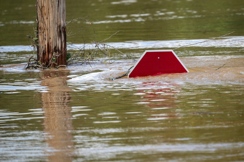 A stop sign can be barely seen above a flooded parking lot after torrential rain from Hurricane Helene caused severe flooding, Saturday, Sept. 28, 2024, in Morganton, N.C.  (AP Photo/Kathy Kmonicek)